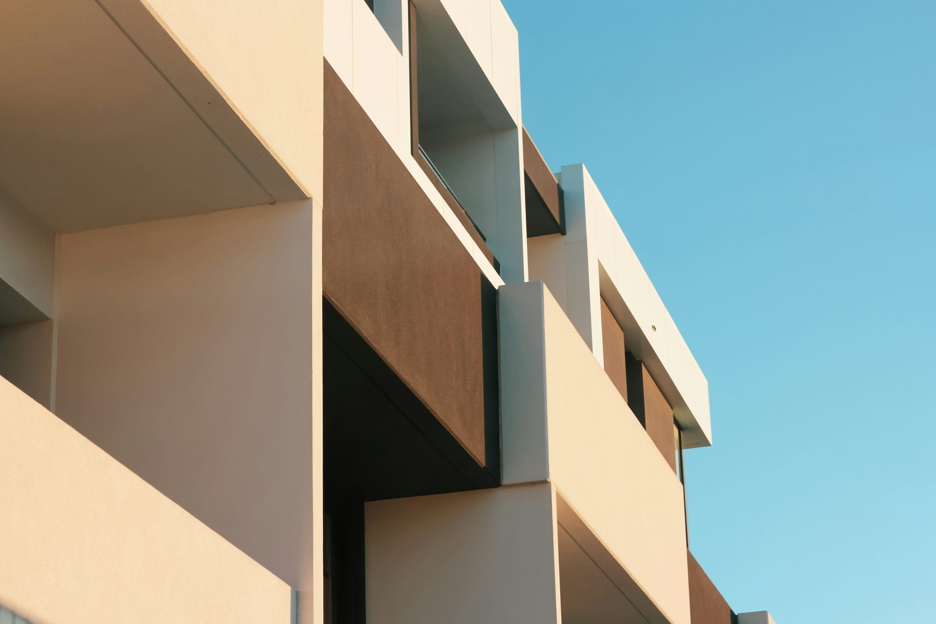 beiges Betongebäude unter blauem Himmel tagsüber