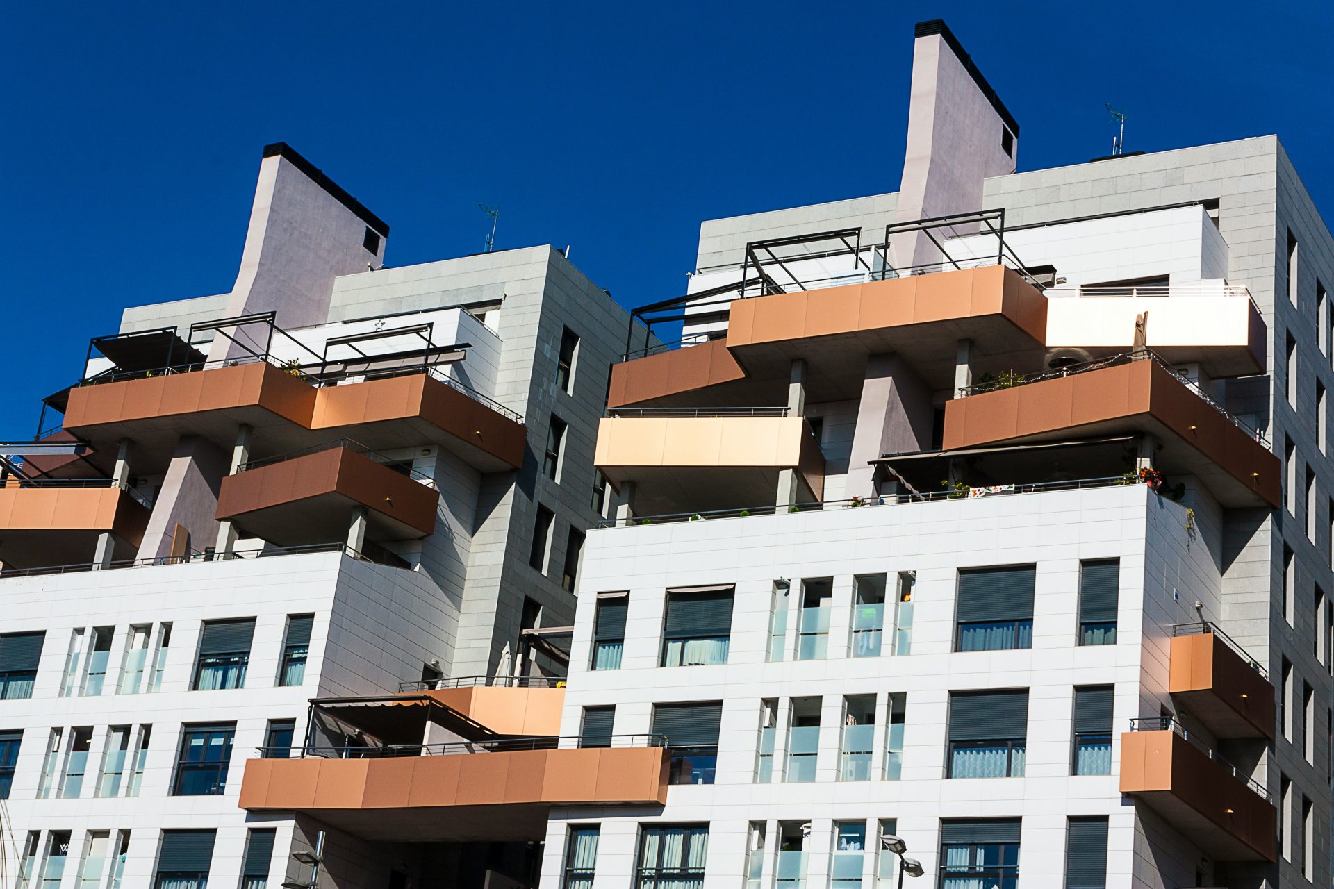 weißes und braunes Betongebäude unter blauem Himmel tagsüber