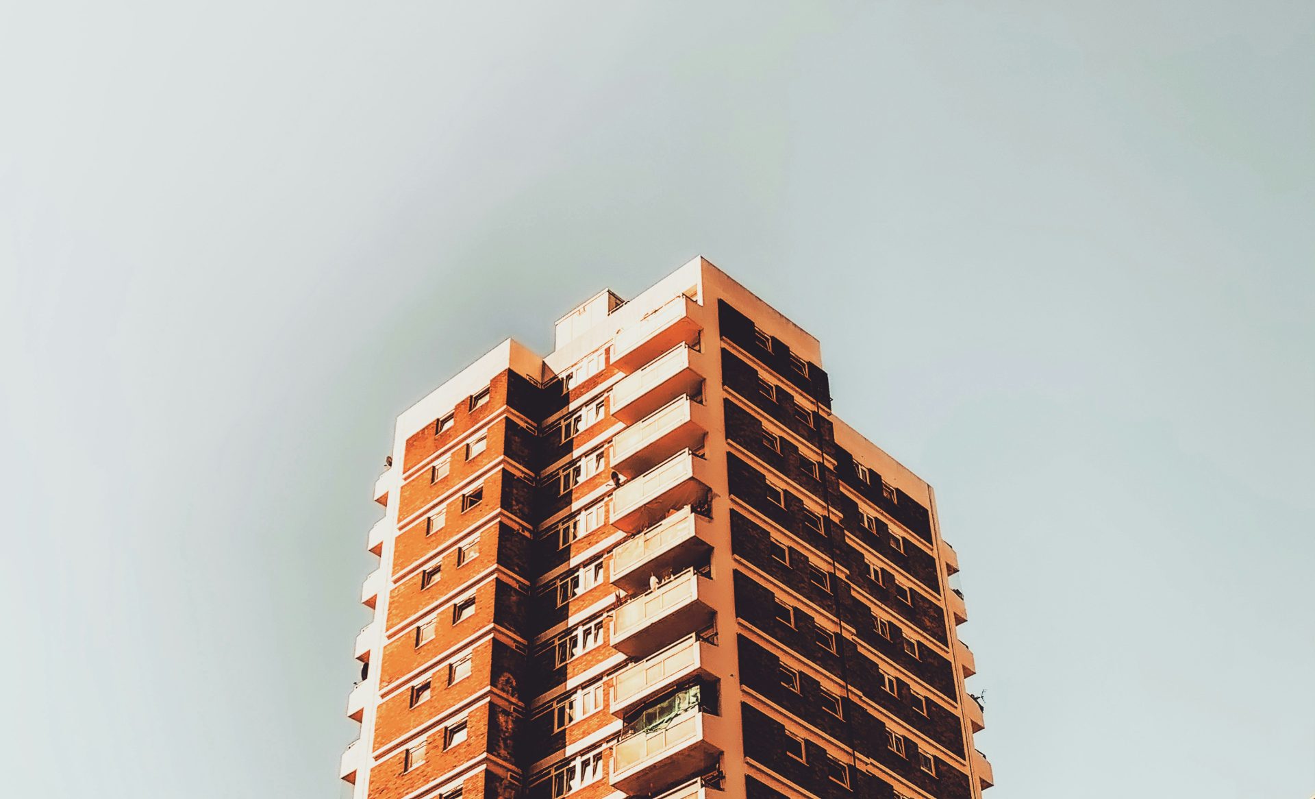 ein hohes Gebäude mit Balkonen vor blauem Himmel