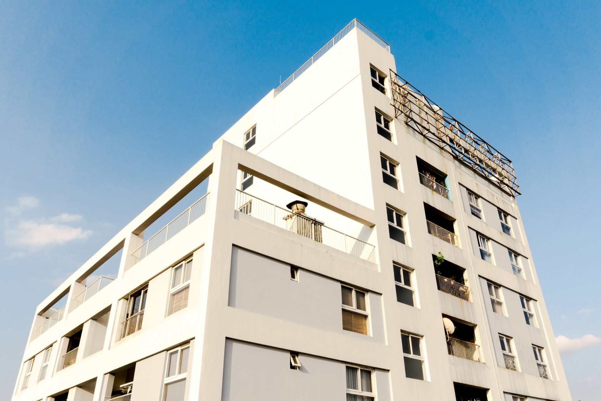 weißes Betongebäude unter blauem Himmel tagsüber